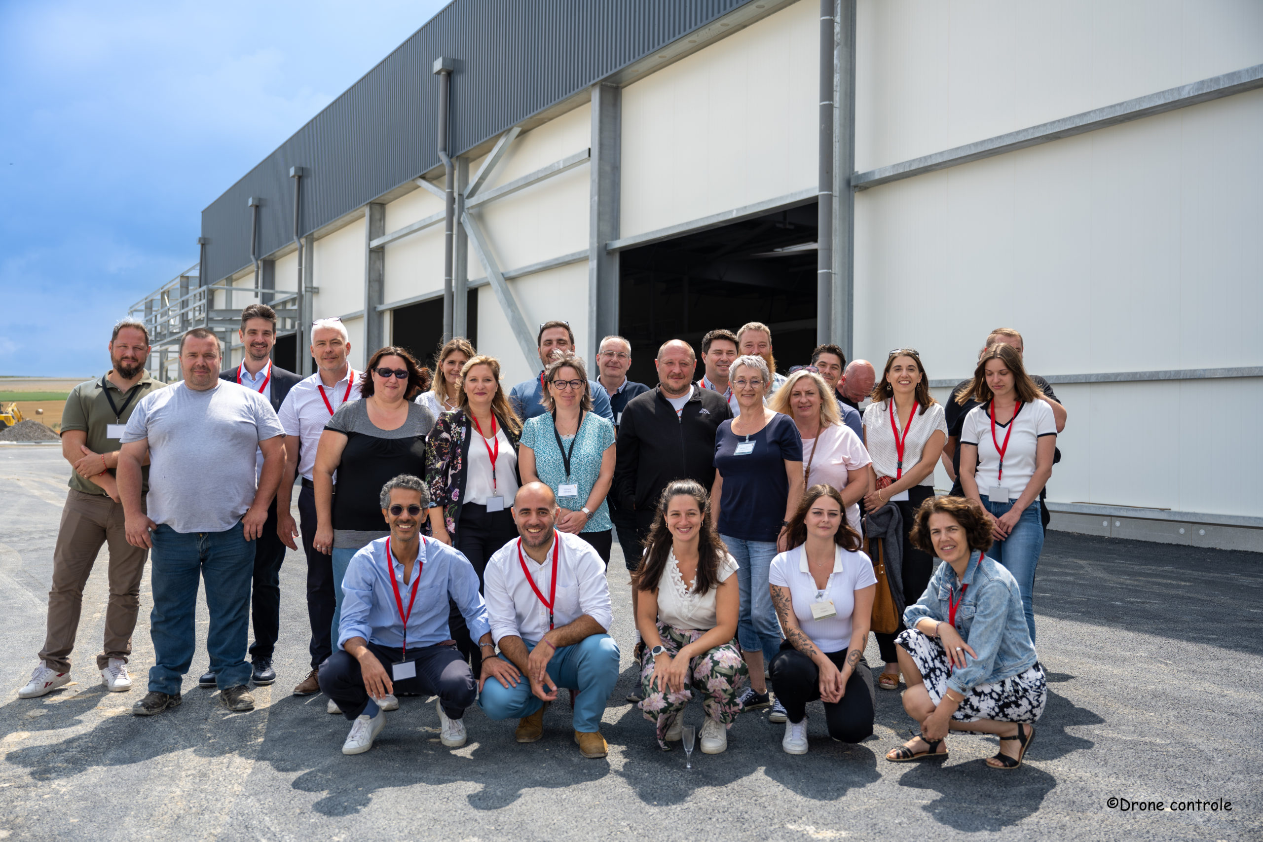 Group of employees outside industrial facility.