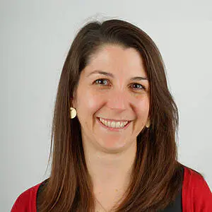 Smiling woman with brown hair, red top.