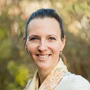 Woman smiling outdoors in natural light.