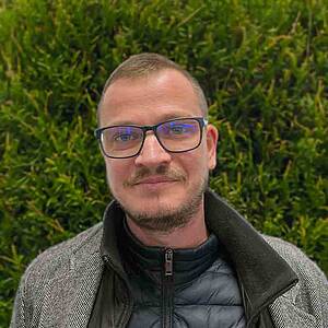 Man with glasses smiling.