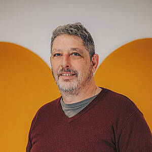 Man smiling, orange background