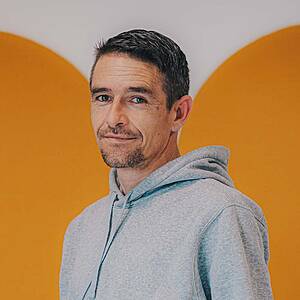 Man in gray hoodie smiling