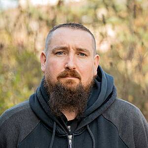 Man with beard in hoodie outdoors
