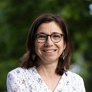 Smiling woman wearing glasses outdoors.